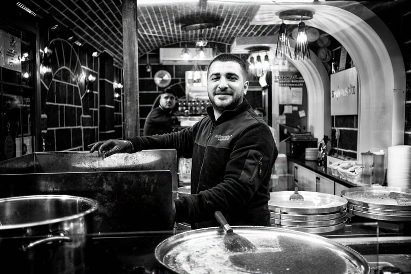 A worker posing in the street food shop where he works