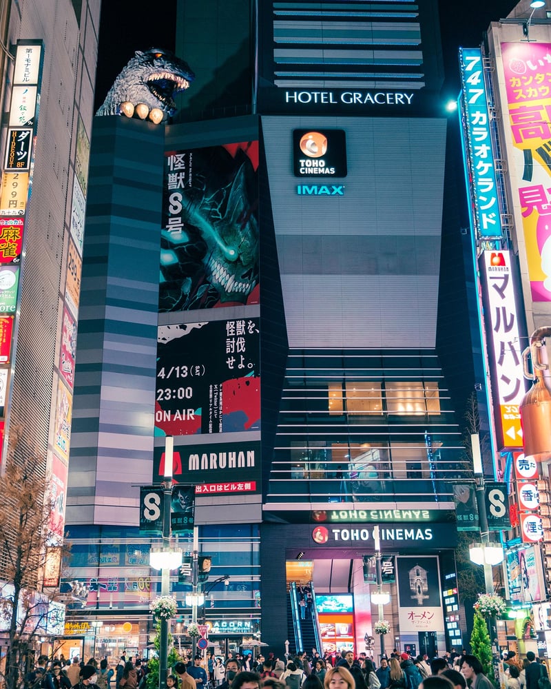 Godzilla watches the street below from the rooftop of the IMAX cinema of Shinjuku