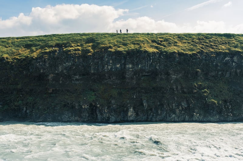 Some visitors on top of the cliff standing above Gullfoss