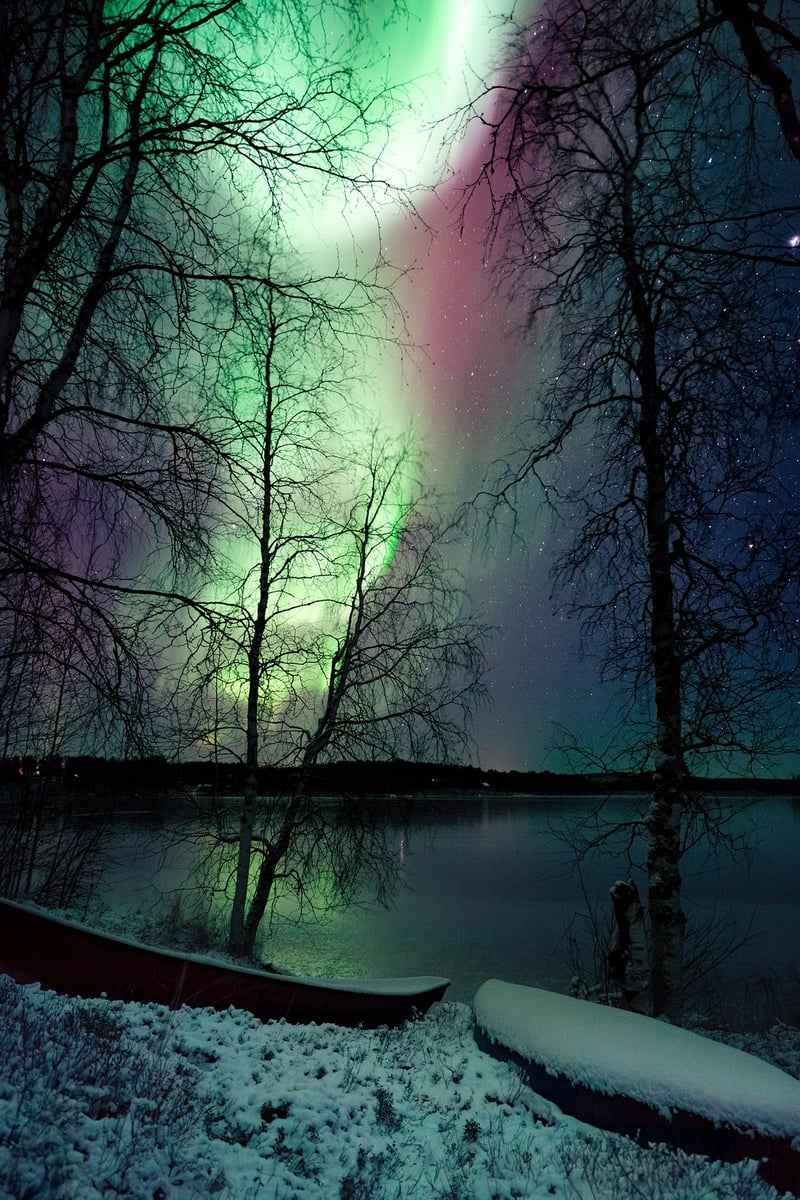 Northen lights behind a couple of boats.