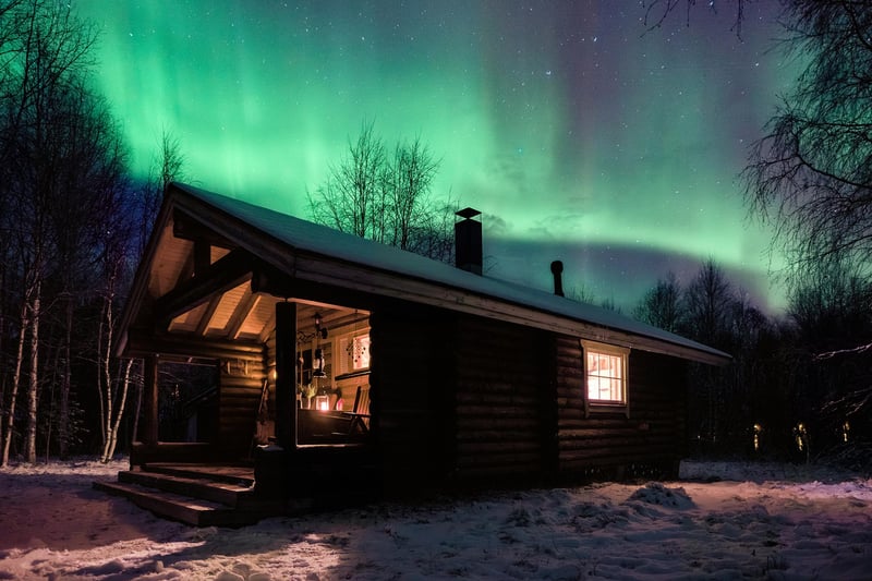 The northen lights above a cozy cottage.